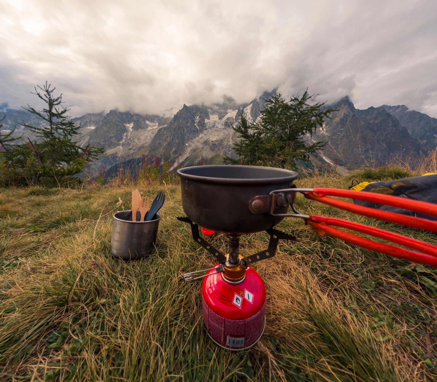 Portable camping stove at an alpine campsite with mountain views